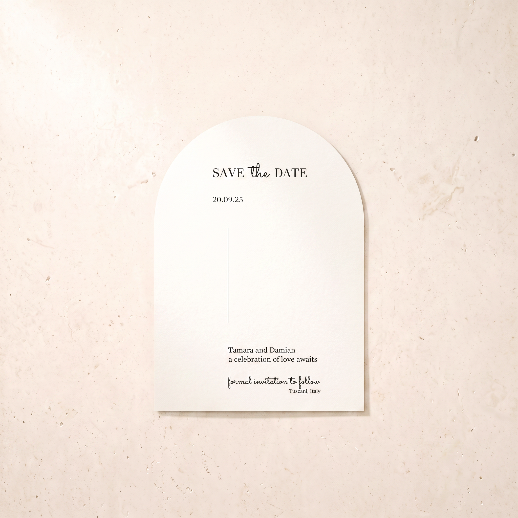 An arched white paper save-the-date card with elegant black typography, displayed flat against a textured beige stone background.