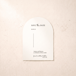 An arched white paper save-the-date card with elegant black typography, displayed flat against a textured beige stone background.