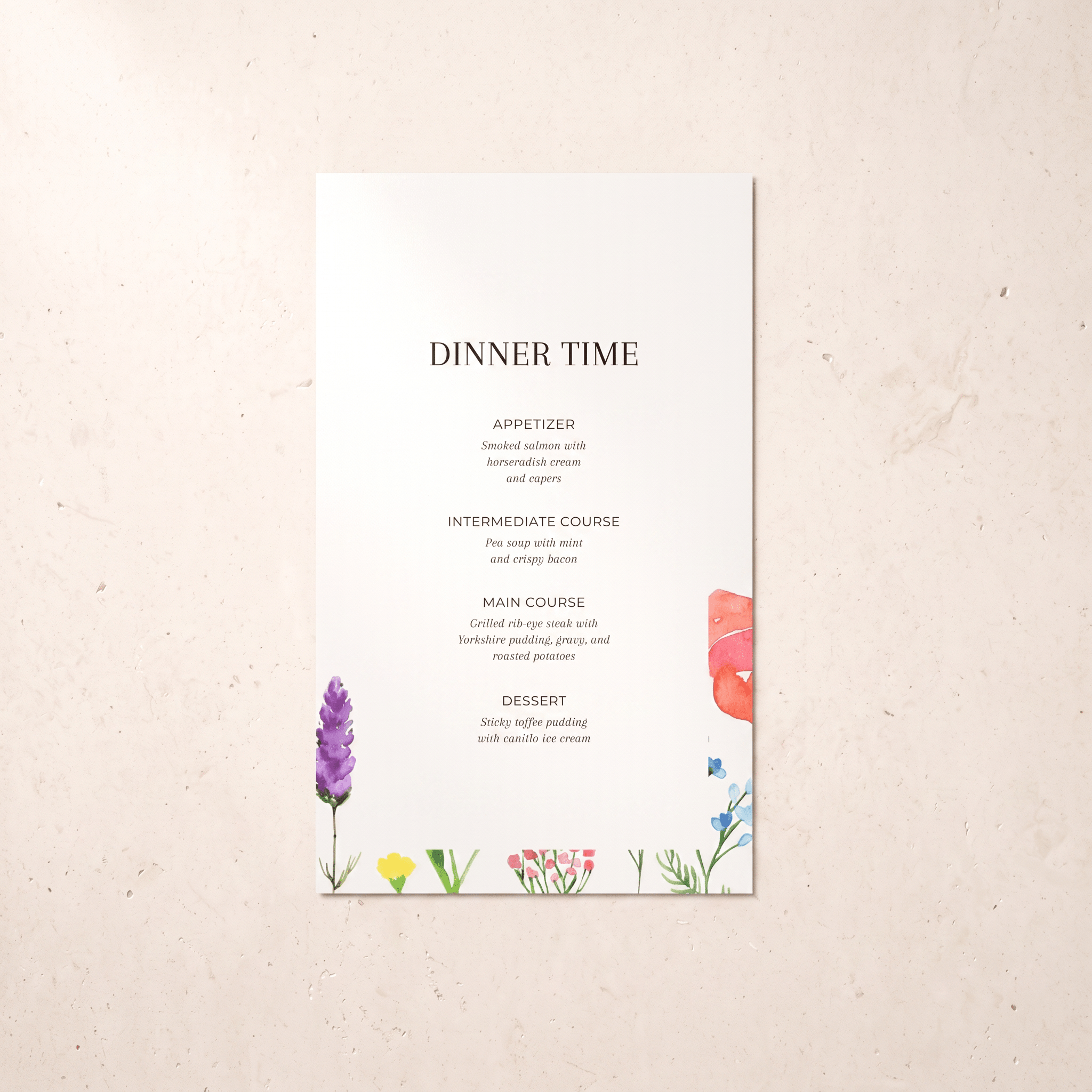 A vertical wedding dinner time menu card with elegant black typography on a white background, decorated with colorful watercolor floral illustrations at the bottom and right edge, displayed on a textured light beige surface.