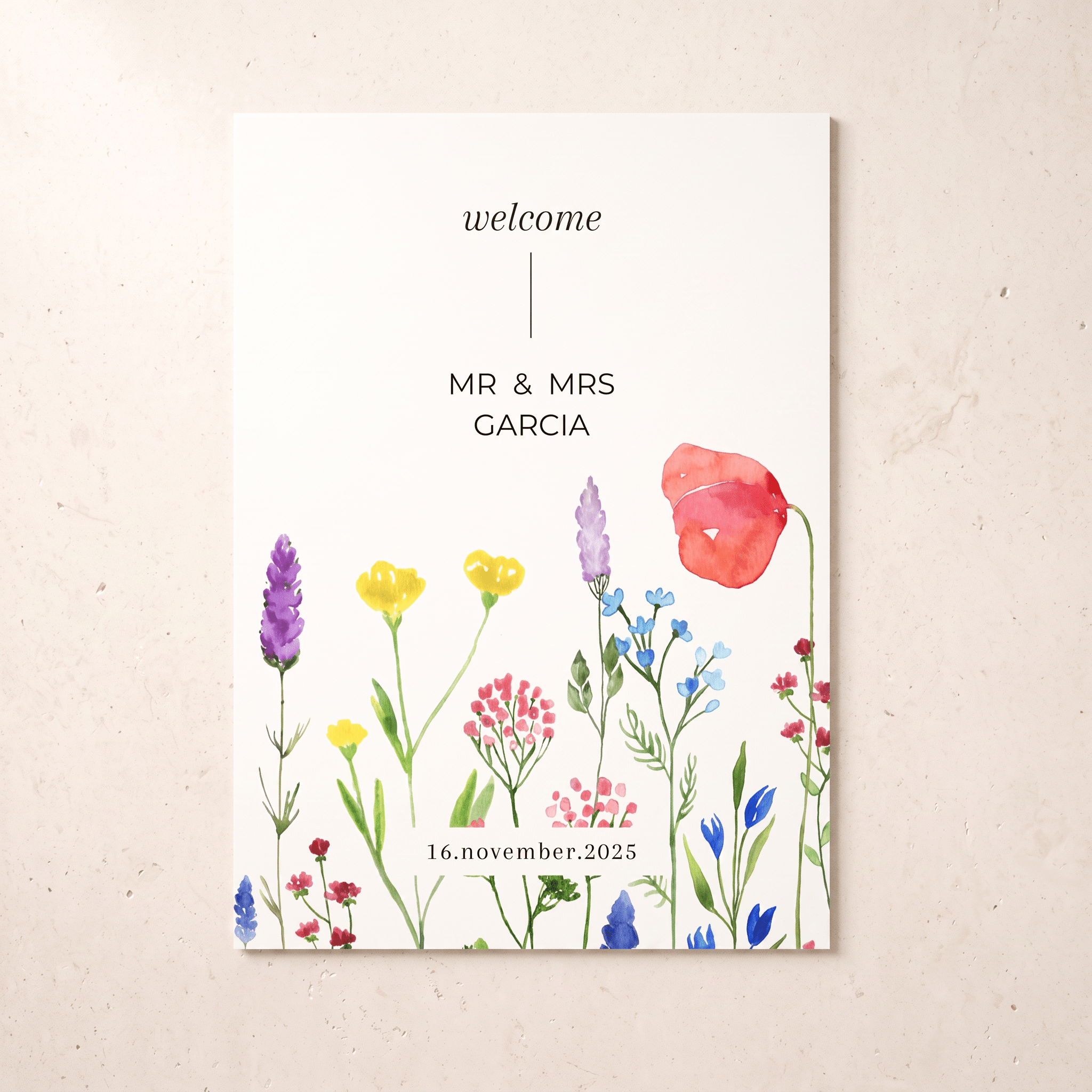 A vertical wedding welcome card with a watercolor floral border, displayed against a light beige textured background. The card features the text 'welcome', 'MR & MRS GARCIA', and the date '16.