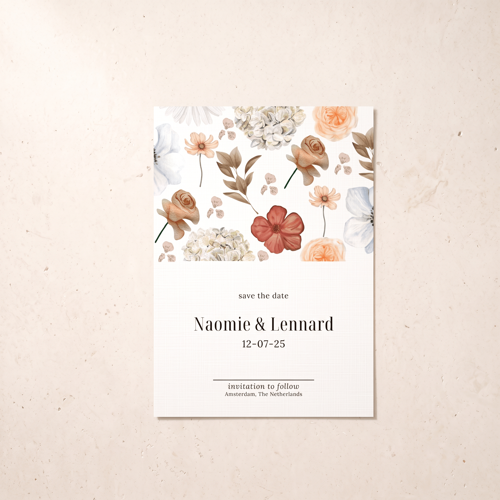 A vertical 'save the date' card with a watercolor floral design at the top and elegant black text below, displayed flat on a textured beige surface.