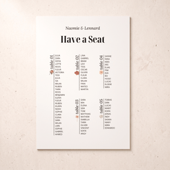 A vertical white wedding seating chart print with the names 'Naomie & Lennard' at the top and columns labeled table 01 through table 05, photographed against a light beige textured background.