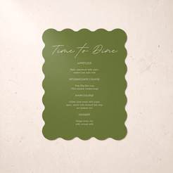 An olive green menu card with scalloped edges and white script text reading 'Time to Dine' and course listings, centered on a light beige textured background.