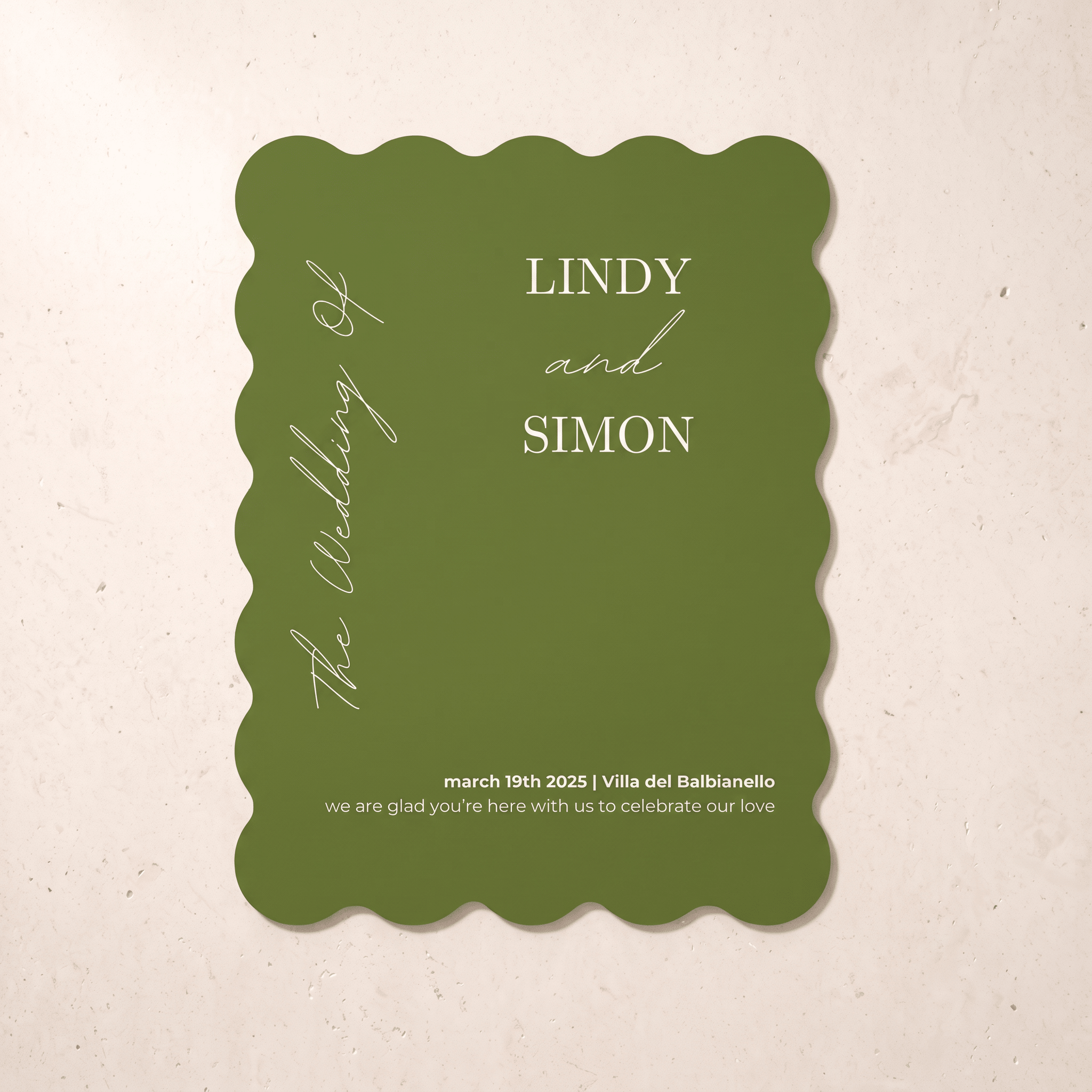 A scalloped-edge olive green wedding invitation card with white text, displayed flat against a light beige textured background.