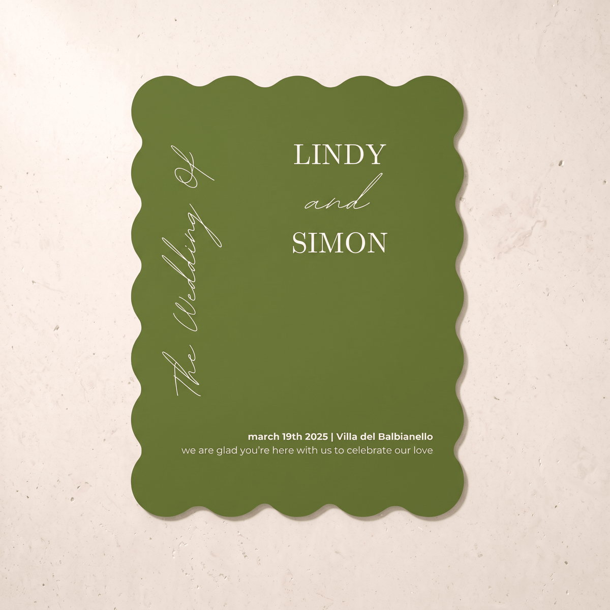 A scalloped-edge olive green wedding invitation card with white text, displayed flat against a light beige textured background.