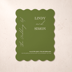A scalloped-edge olive green wedding invitation card with white text, displayed flat against a light beige textured background.