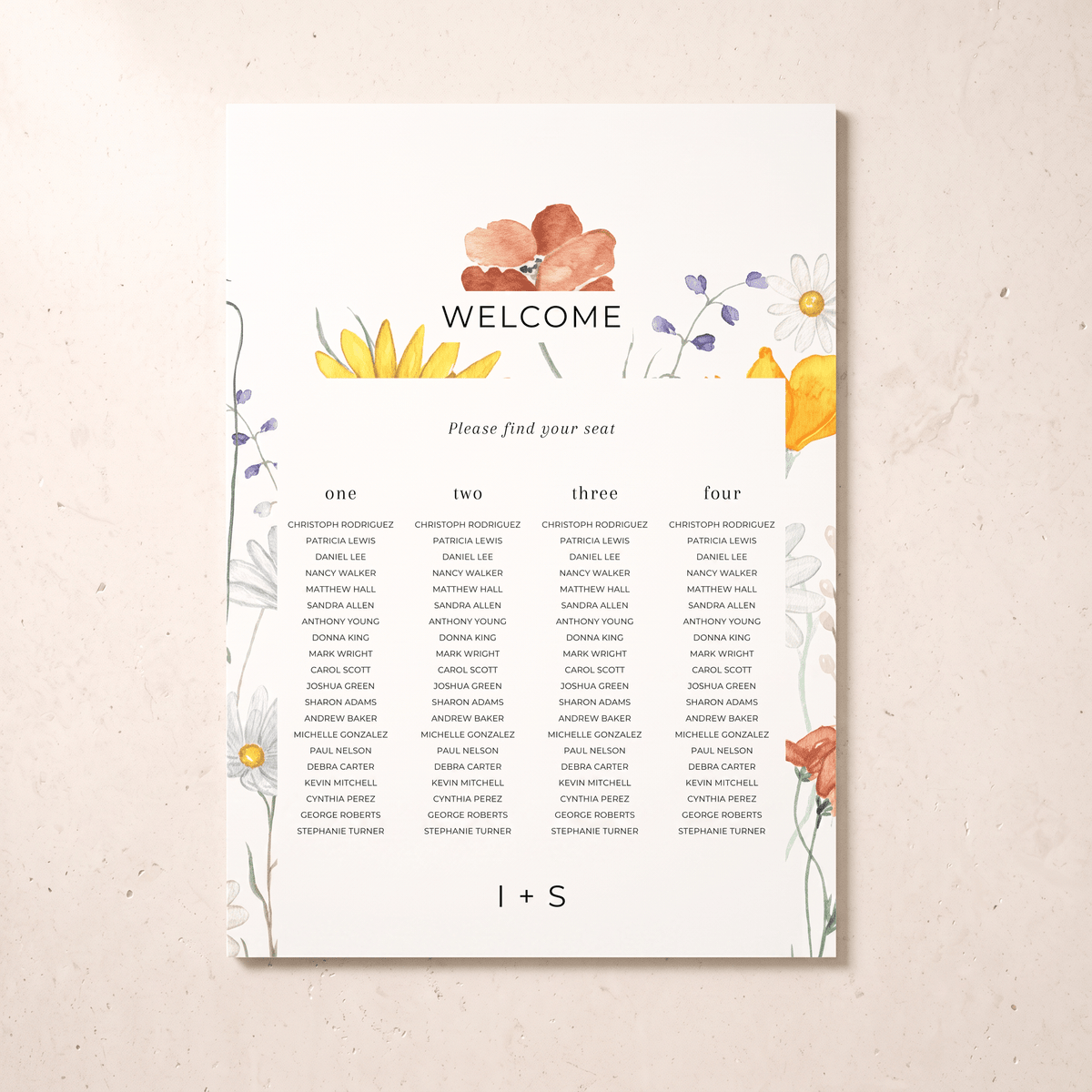 A printed wedding welcome seating card with floral watercolor illustrations in yellow, orange, purple, and blue, displayed against a light beige textured background. The card includes columns for guests numbered one through four and the text 'WELCOME' and 'Please find your seat'.