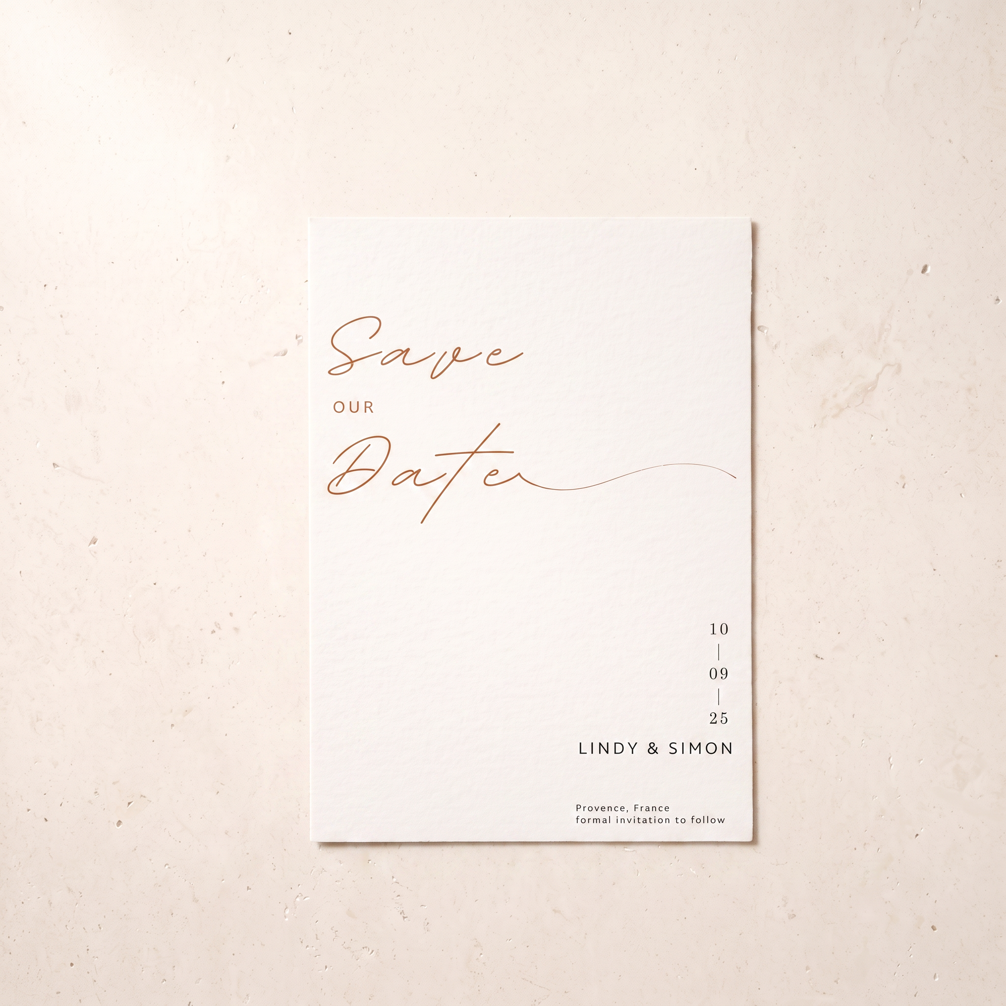A minimalist 'Save Our Date' wedding card with elegant rose gold script and black text on a clean white card, displayed flat on a textured beige surface.