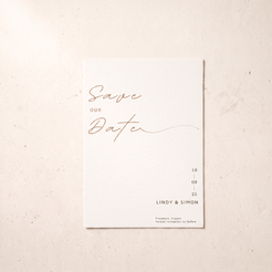 A minimalist 'Save Our Date' wedding card with elegant rose gold script and black text on a clean white card, displayed flat on a textured beige surface.