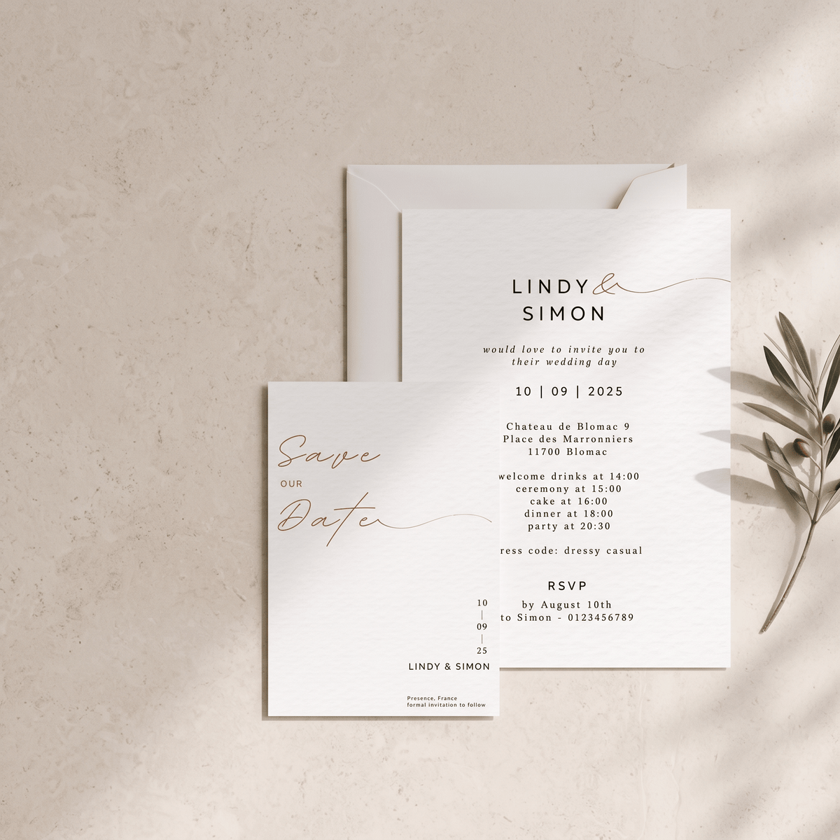 A wedding save-the-date card and matching invitation envelope arranged on a light beige textured surface with a small olive branch prop. The cards are white with black serif and script text and rose-gold cursive accents.