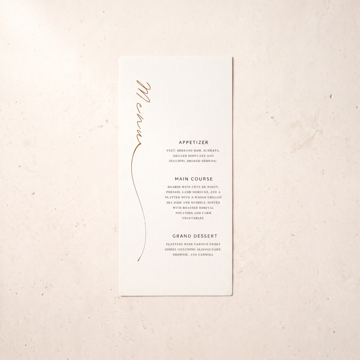 A tall, narrow white wedding menu card with elegant rose gold foil script reading 'Michelle' and black printed event details, displayed flat on a textured beige surface.