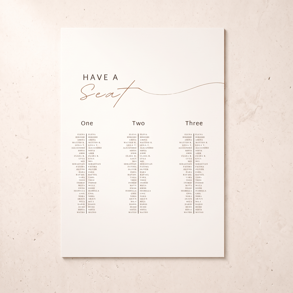 A vertical wedding seating chart print with the text 'HAVE A Seat' in black and rose-gold script, plus three columns labeled One, Two, and Three with small printed names beneath, shown on a light warm beige background.